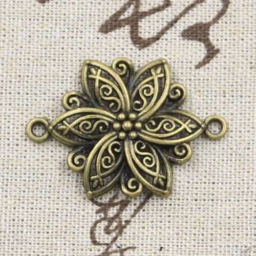 Connecteur couleur bronze en fleur à six pétales pointus, volutes en relief et deux œillets
