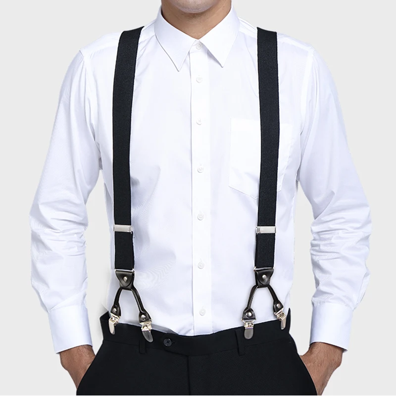 Bretelles noires portées sur une chemise blanche avec quatre pinces métalliques fixées à l’avant du pantalon