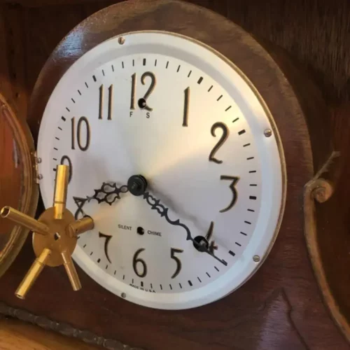 Clé de remontage à cinq branches présentée près du cadran d’une horloge mécanique